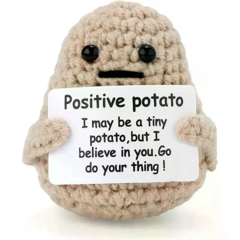 A handmade plush potato doll with a light brown, textured body and black features.