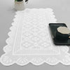 White lace table runner with a geometric pattern and a black serving dish.
