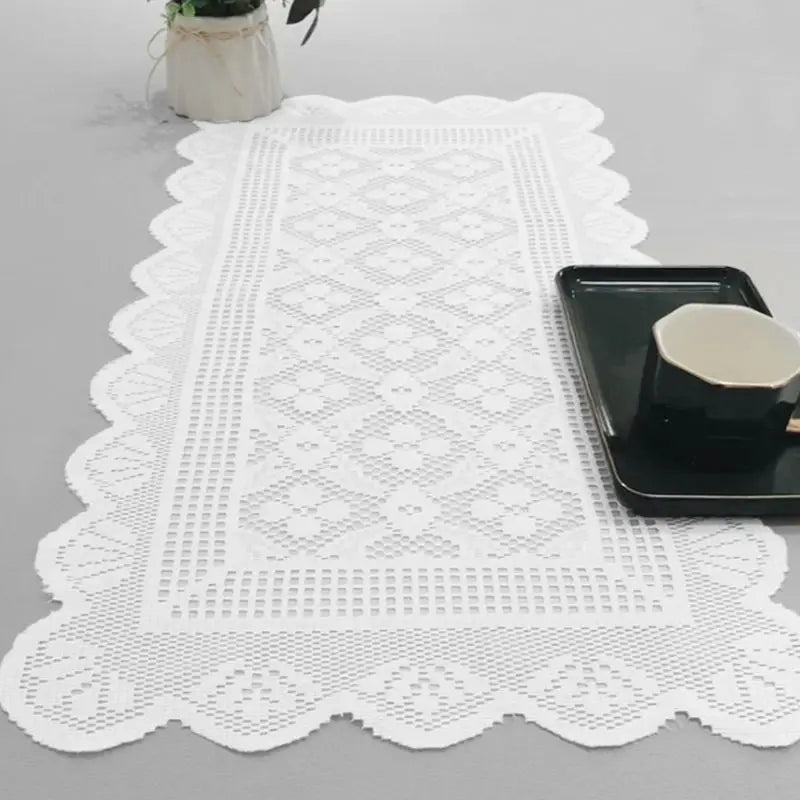 White lace table runner with a geometric pattern and a black serving dish.