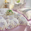 A lavender print duvet cover set featuring floral patterns and matching pillowcases on a bed.