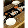 Halloween table runner featuring a black background with orange pumpkin and white spider designs on a wooden table.