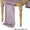 A purple semi-sheer gauze table runner draped elegantly on a wooden table.