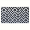 A black and white geometric patterned outdoor rug with a diamond lattice design.