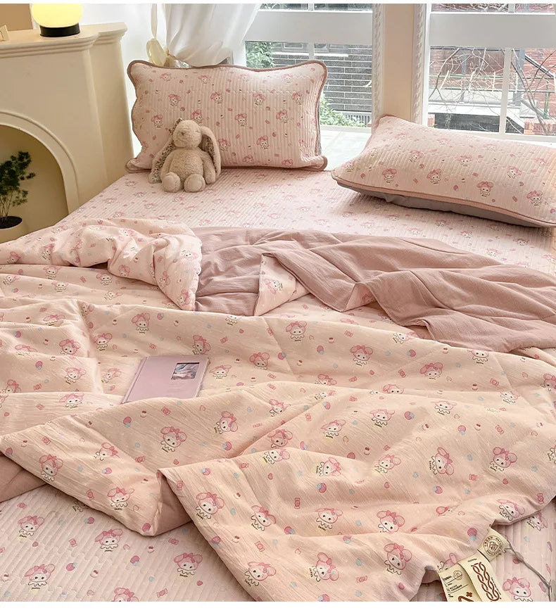 Pink cartoon quilting comforter with small animal patterns displayed on a bed.