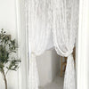 White floral embroidery sheer curtain hanging in a doorway