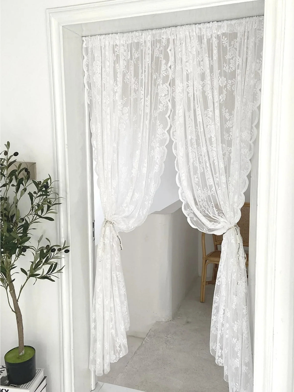 White floral embroidery sheer curtain hanging in a doorway