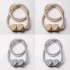 A set of four beige and silver magnetic curtain tiebacks, featuring textured rope designs.