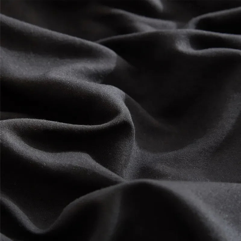 A close-up of a dark gray soft washed duvet cover fabric with visible folds and texture.