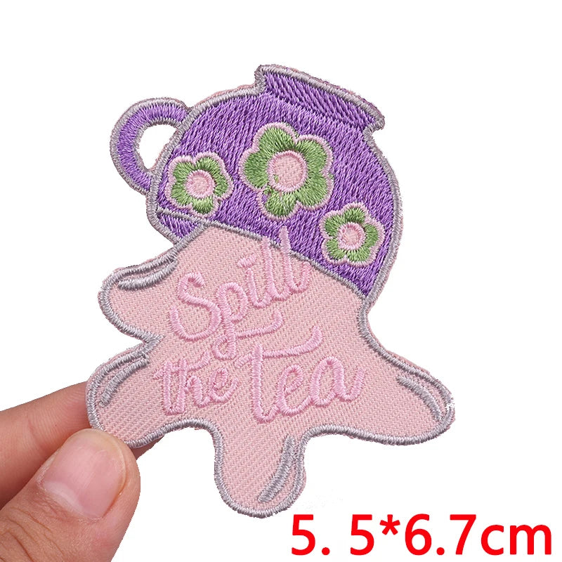 Purple and pink embroidered patch featuring a teapot design with the text Spill the tea