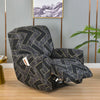 A black and gold patterned floral print recliner and sofa slipcover set displayed in a modern room.