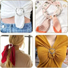 Close-up of round heart button clips used to fasten clothing and accessories on a white blouse and yellow top.