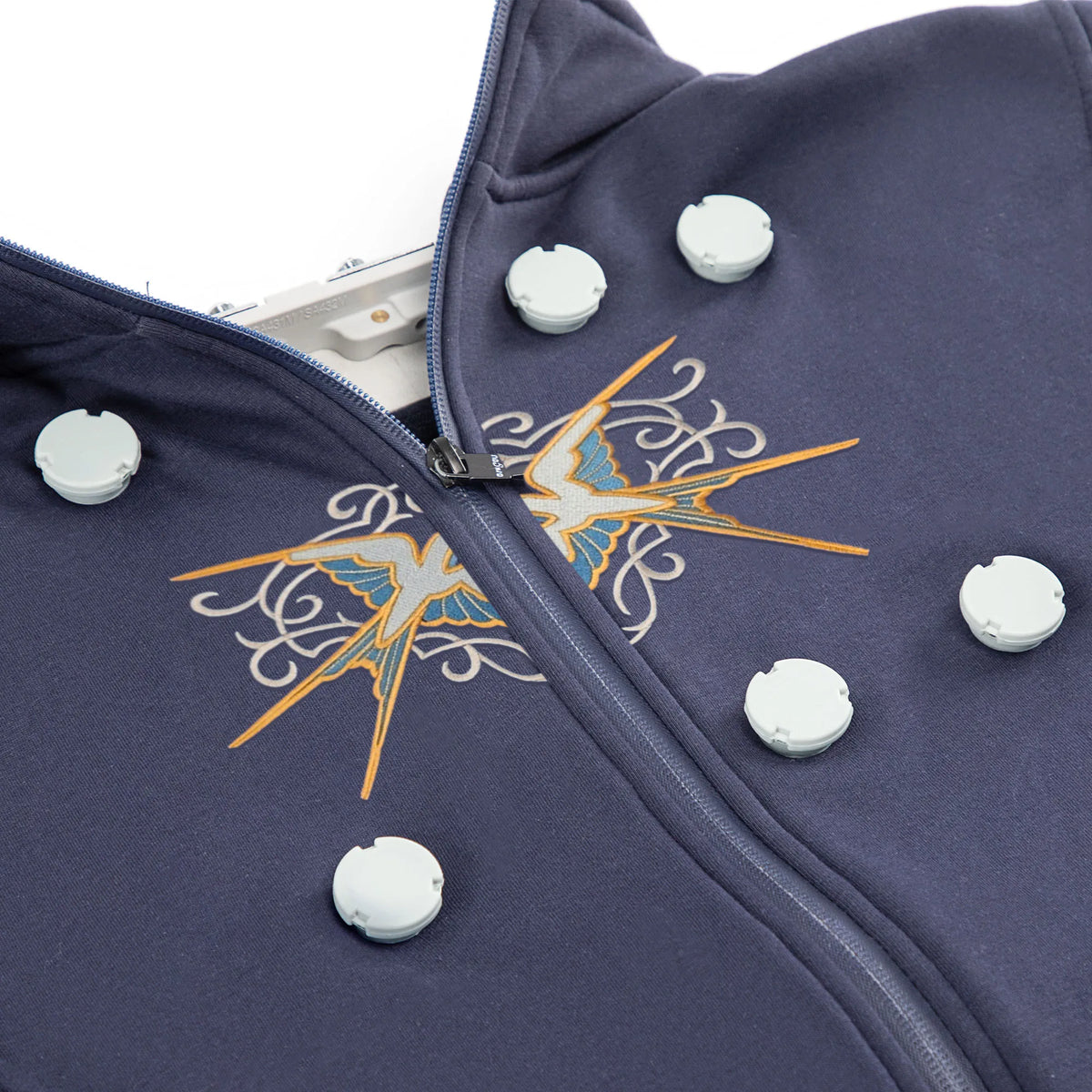 A dark blue magnetic embroidery hoop set with a zipper and decorative stitching on the fabric.