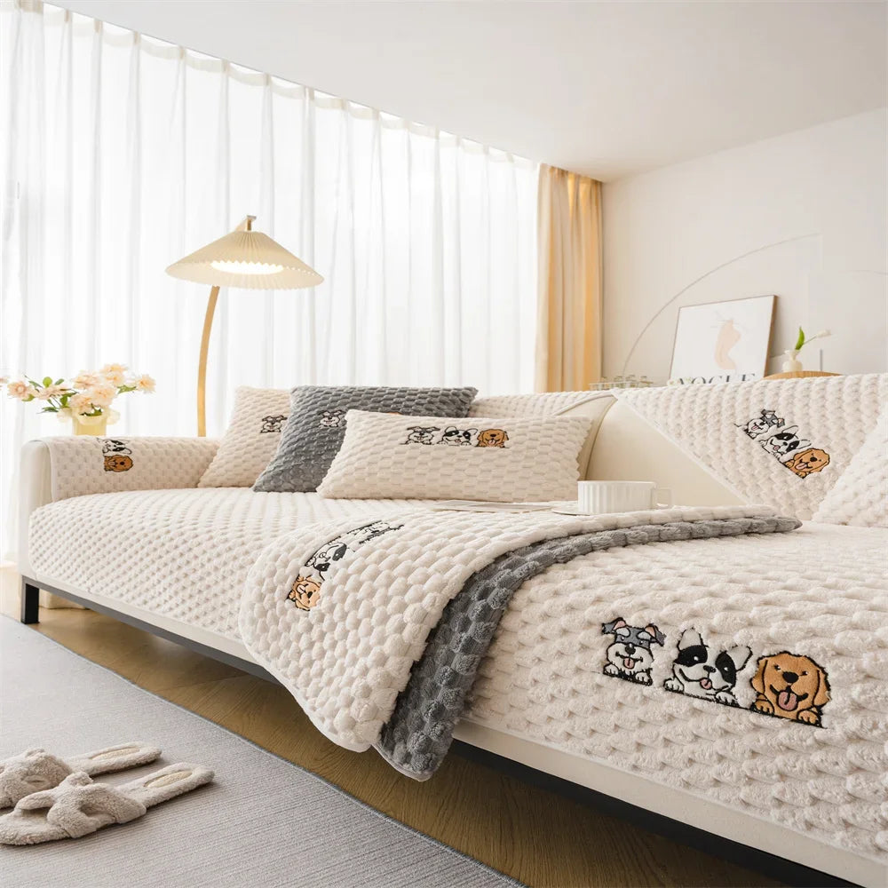 A white knitted plush sofa cover with brown and black animal designs displayed on a modern bed.