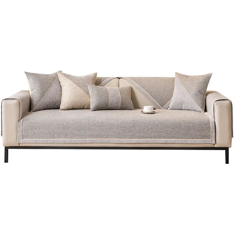 A beige woven sofa cushion cover with light gray accent pillows on a modern sofa.