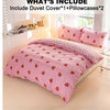 A pink strawberry print duvet cover set with two pillowcases displayed on a bed.