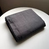 A dark gray pure linen flat sheet folded neatly on a white surface.