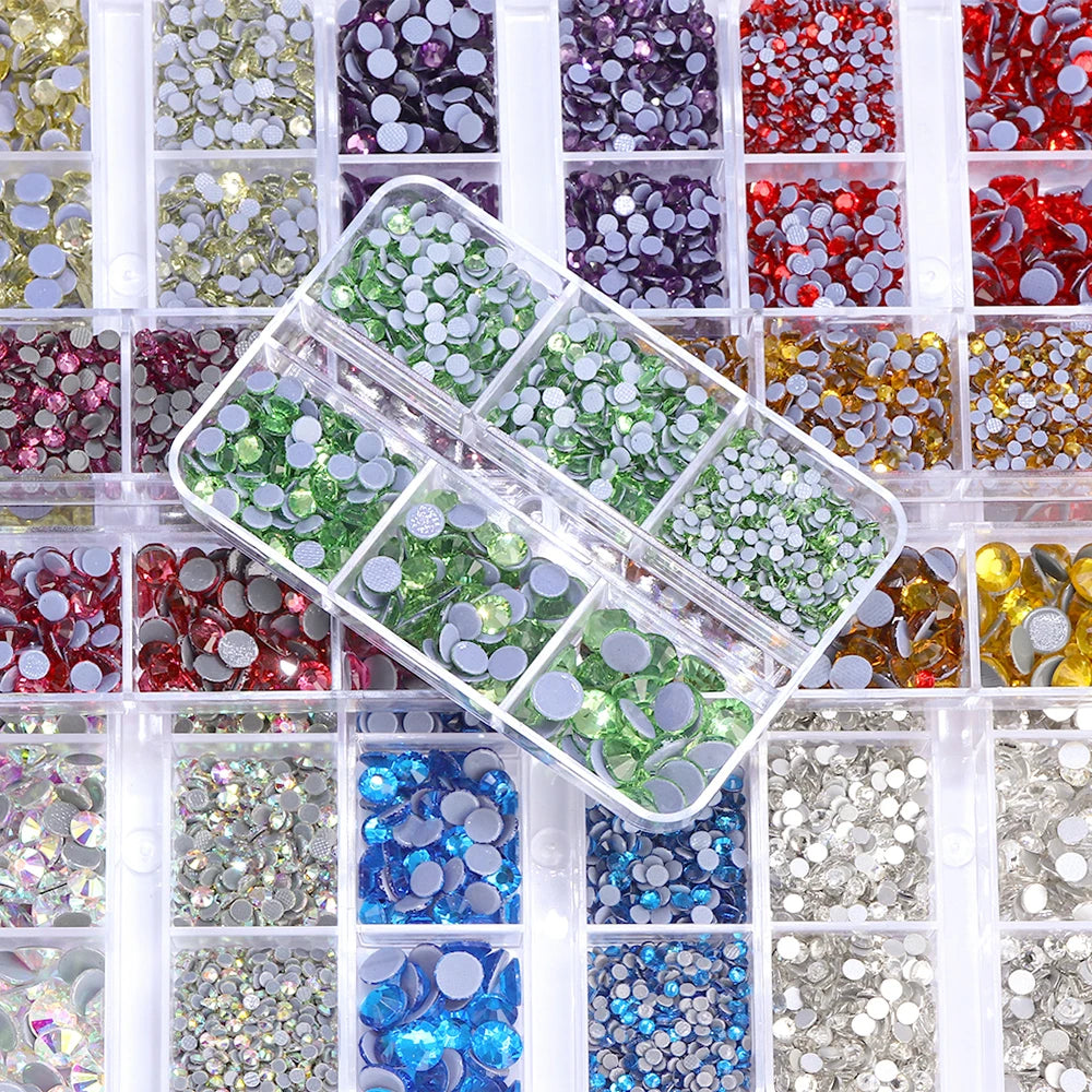 A grid of mixed size hotfix glass rhinestones in various colors and shades for crafts and apparel.