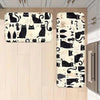 A set of non-slip kitchen mats featuring black cat prints on a light background.