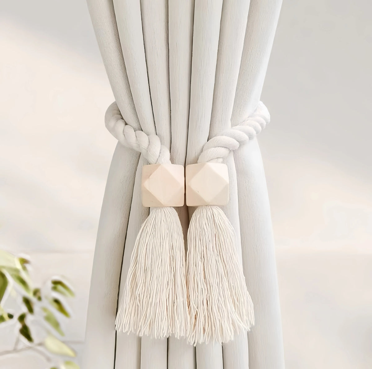 Hand-woven wooden curtain tiebacks tied together with thick white rope and featuring fluffy tassels