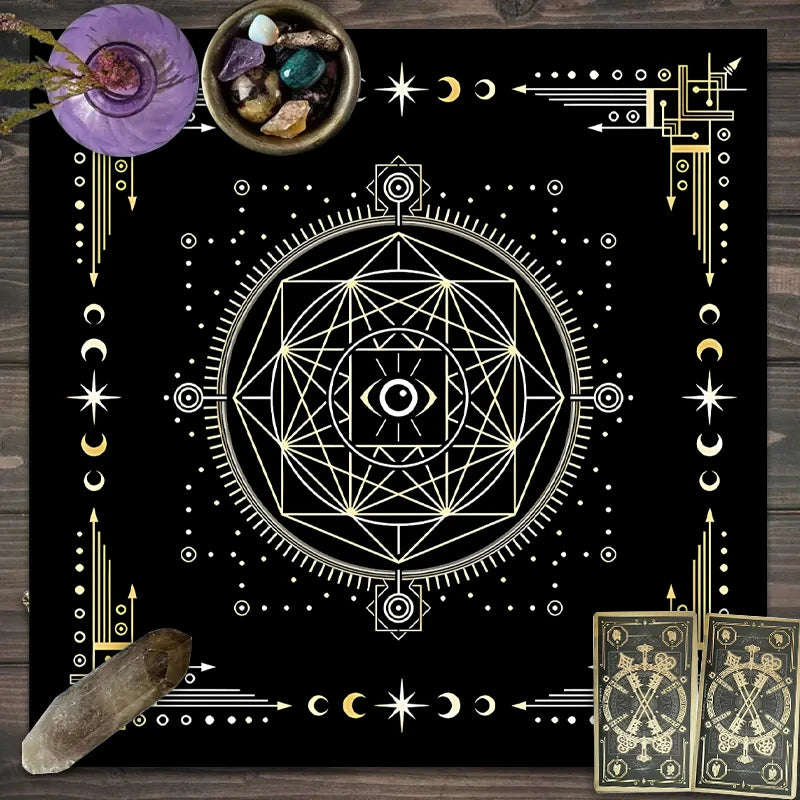 A dark mat featuring a geometric tarot design, celestial symbols, and small bowls with crystals.