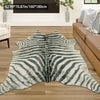 A rectangular gray and white zebra print rug placed on a wooden floor next to a brown sofa.