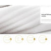 Close-up view of white, fluffy cotton face towels showing texture and softness.