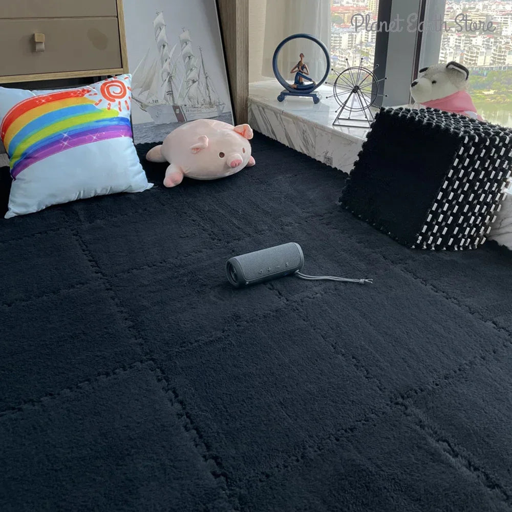 A black interlocking puzzle rug mat with a textured surface is displayed indoors next to pillows and decorative items.
