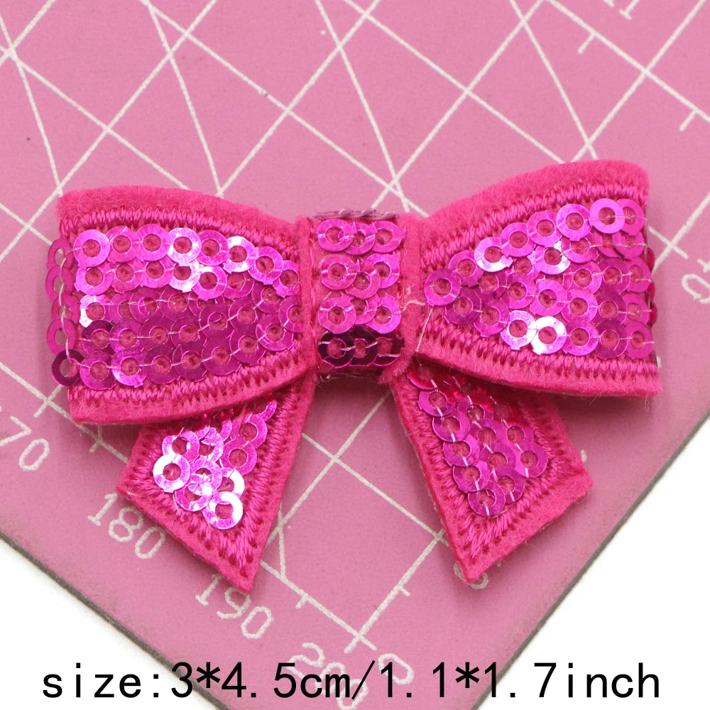 Pink sequin bow patches for DIY decoration shown on a pink background with a ruler.