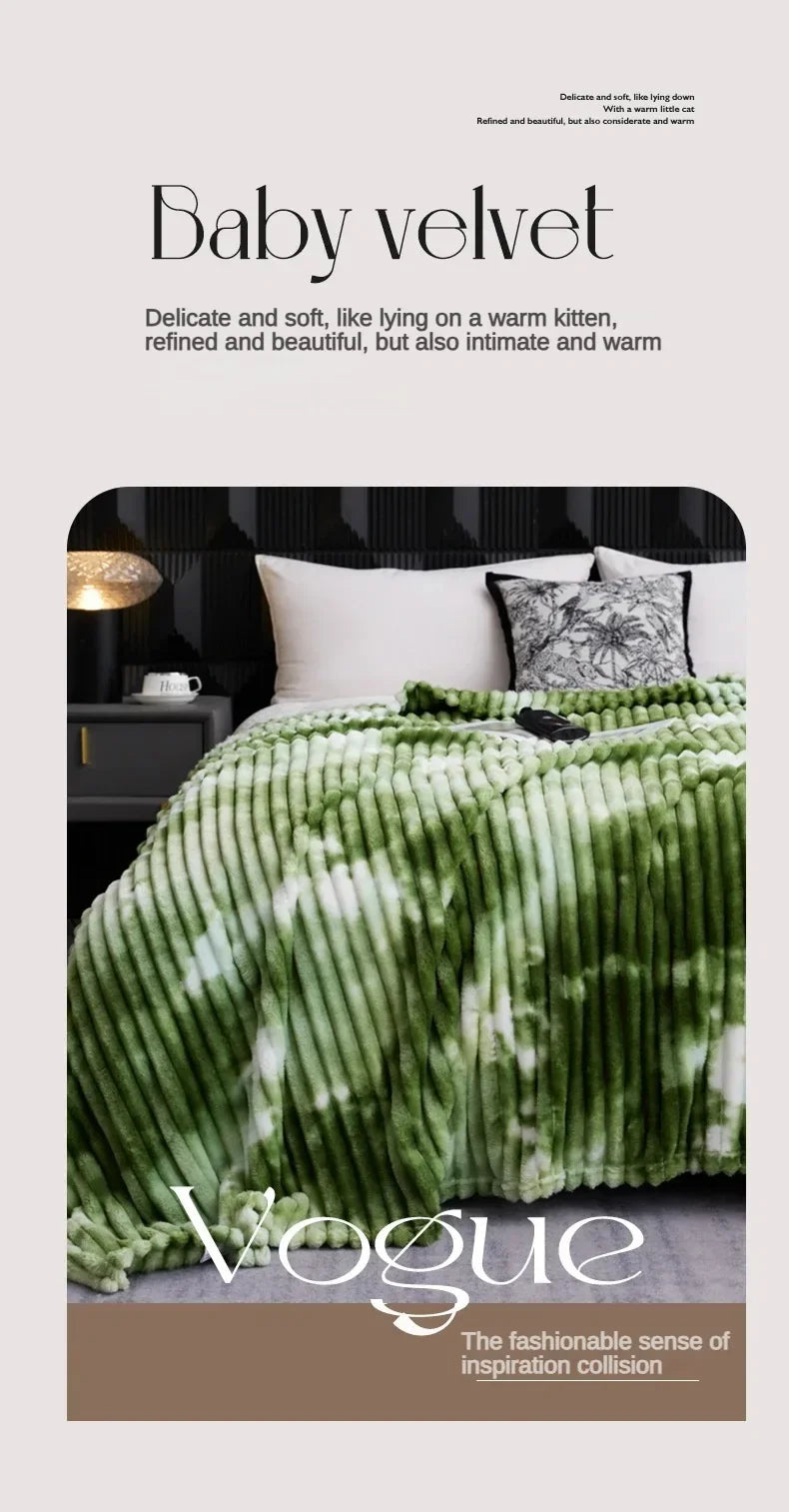 A green and white tie-dye flannel fleece throw blanket draped over a bed.