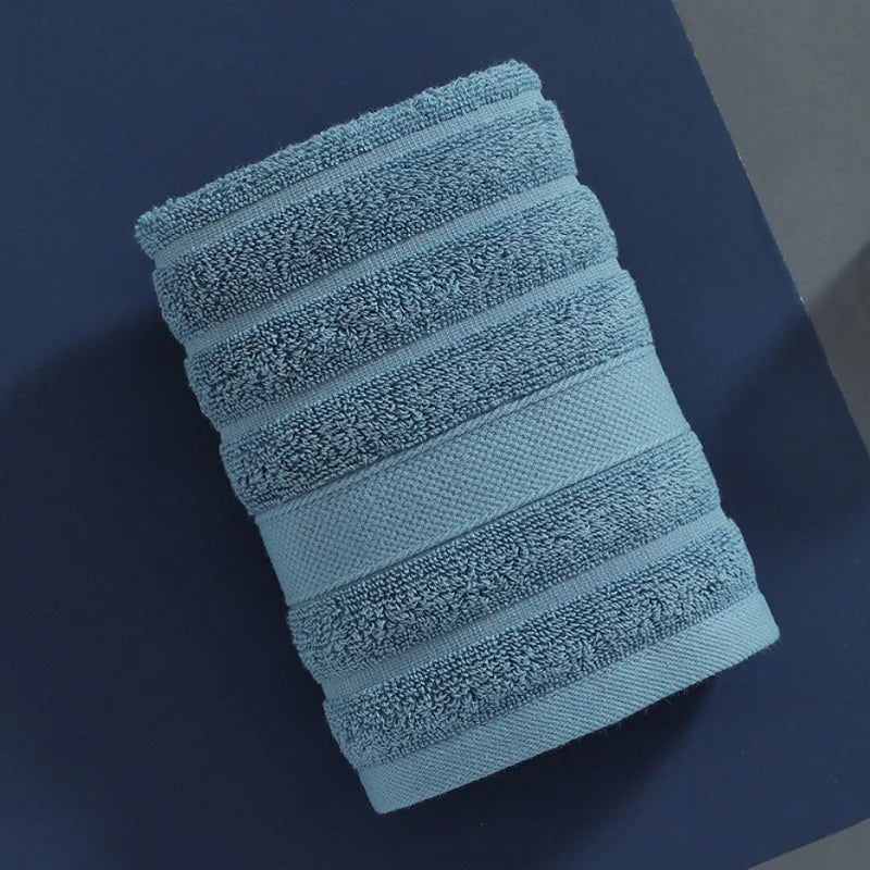 A stack of four light blue textured cotton face towels for kids and adults.