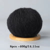 A ball of black premium mohair yarn resting on a wooden base.