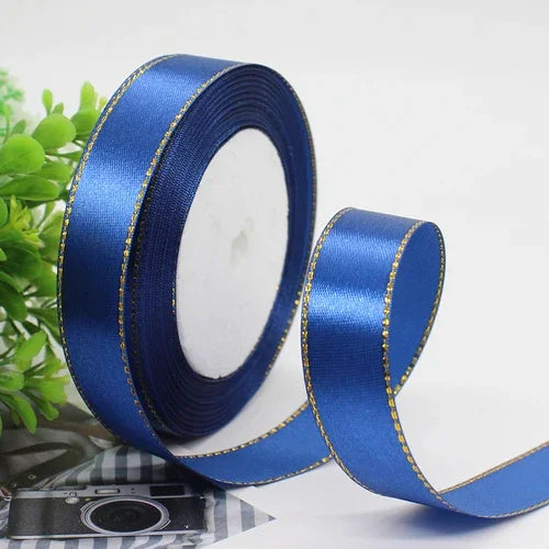 Roll of royal blue satin ribbon with a gold edge for gift wrapping and crafts