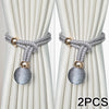 Two silver and gold adjustable French ball curtain tiebacks with braided cord