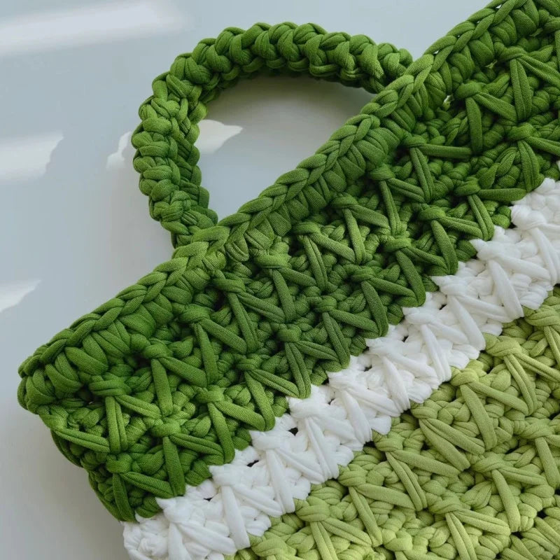 A close-up of a hand-crocheted green and white textured fabric piece.