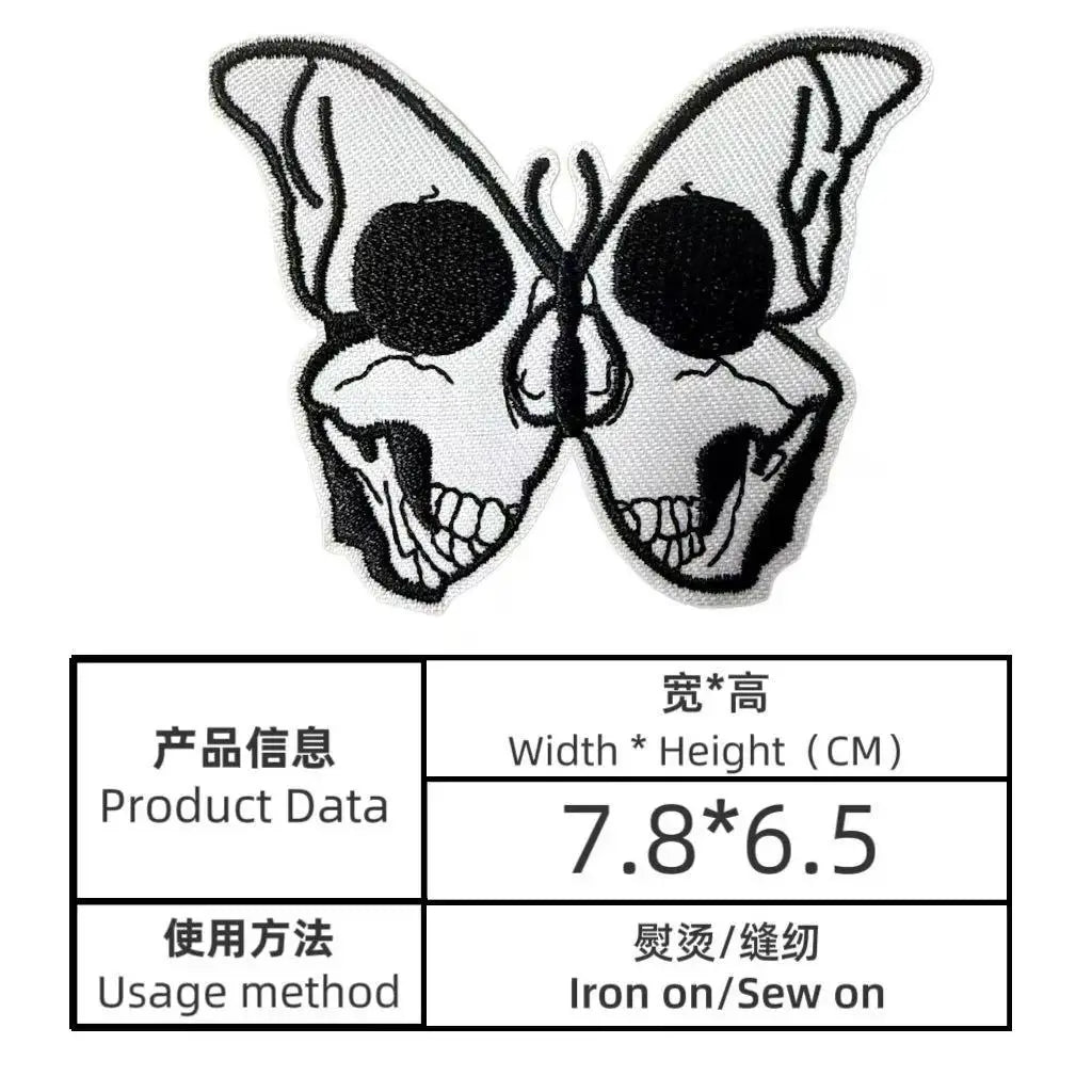 A pair of black and white embroidered butterfly skull iron-on patches.
