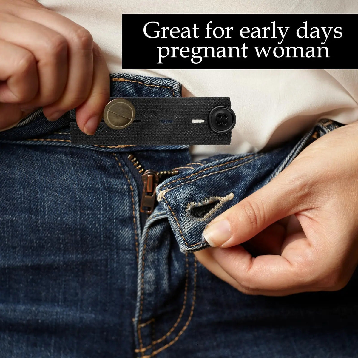 A hand is shown adjusting an adjustable elastic waist extender belt on a pair of blue jeans.