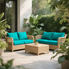 A teal silk elastic sofa slipcover set in a natural wicker frame with a matching coffee table outdoors.