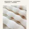 Close-up of a soft, cream-colored plush fabric throw blanket with a fluffy texture.
