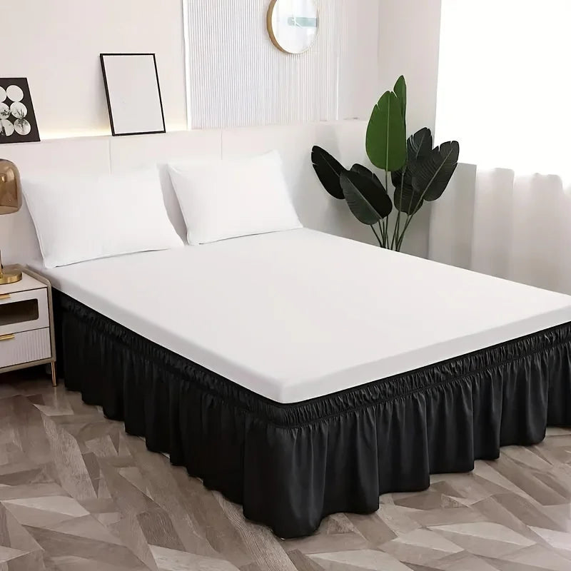 A white bed with a black elastic skirt and white pillows in a modern bedroom setting.