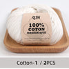 A ball of natural cream colored 100% organic cotton yarn labeled QJH for knitting and crochet
