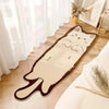 A beige cartoon cat plush rug lying on a light wooden floor next to a white curtain.