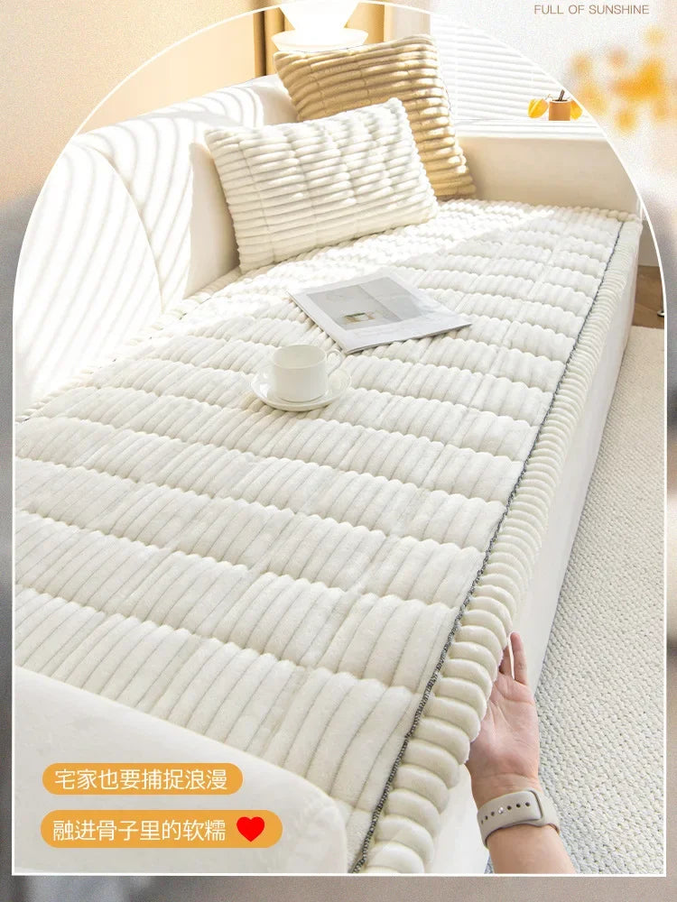 A white quilted sofa armrest cover with a ribbed texture is shown on a bed, next to a hand.