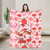 A pink strawberry shortcake plush throw blanket featuring a pattern of strawberries and flowers.