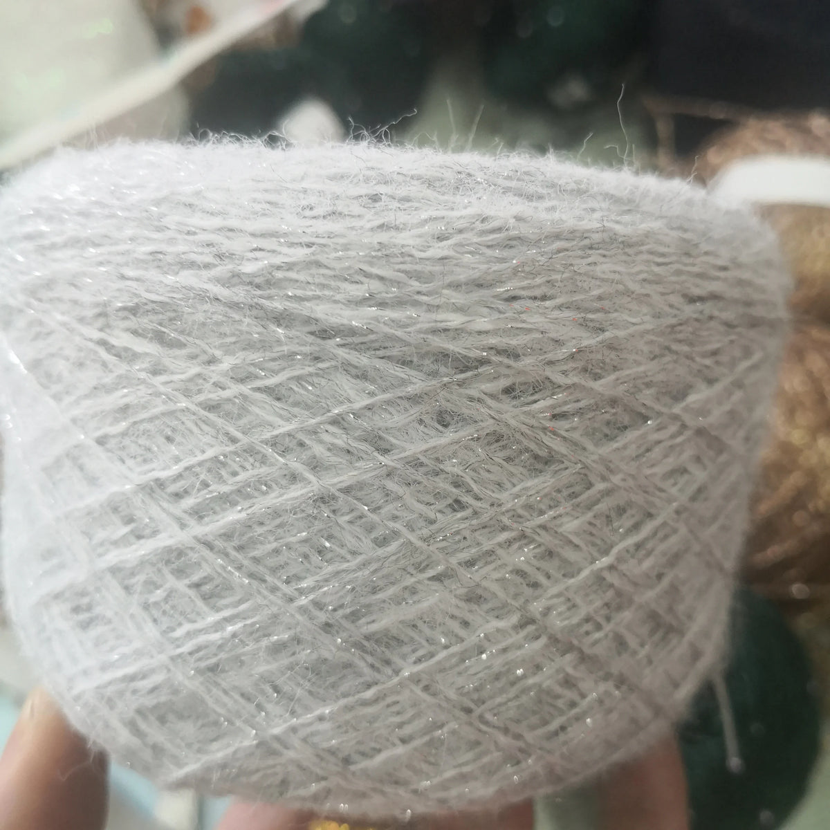 A ball of silver glitter metallic yarn used for crochet and knitting.