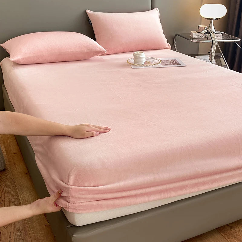 A pink luxury velvet bedding set featuring a sheet and pillow, displayed on a bed.
