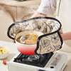 A person is using floral heat-resistant oven mitts to handle a pan on an electric stovetop.