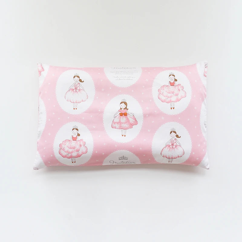 A pink baby pillow cover featuring illustrations of a girl in a dress surrounded by polka dots.