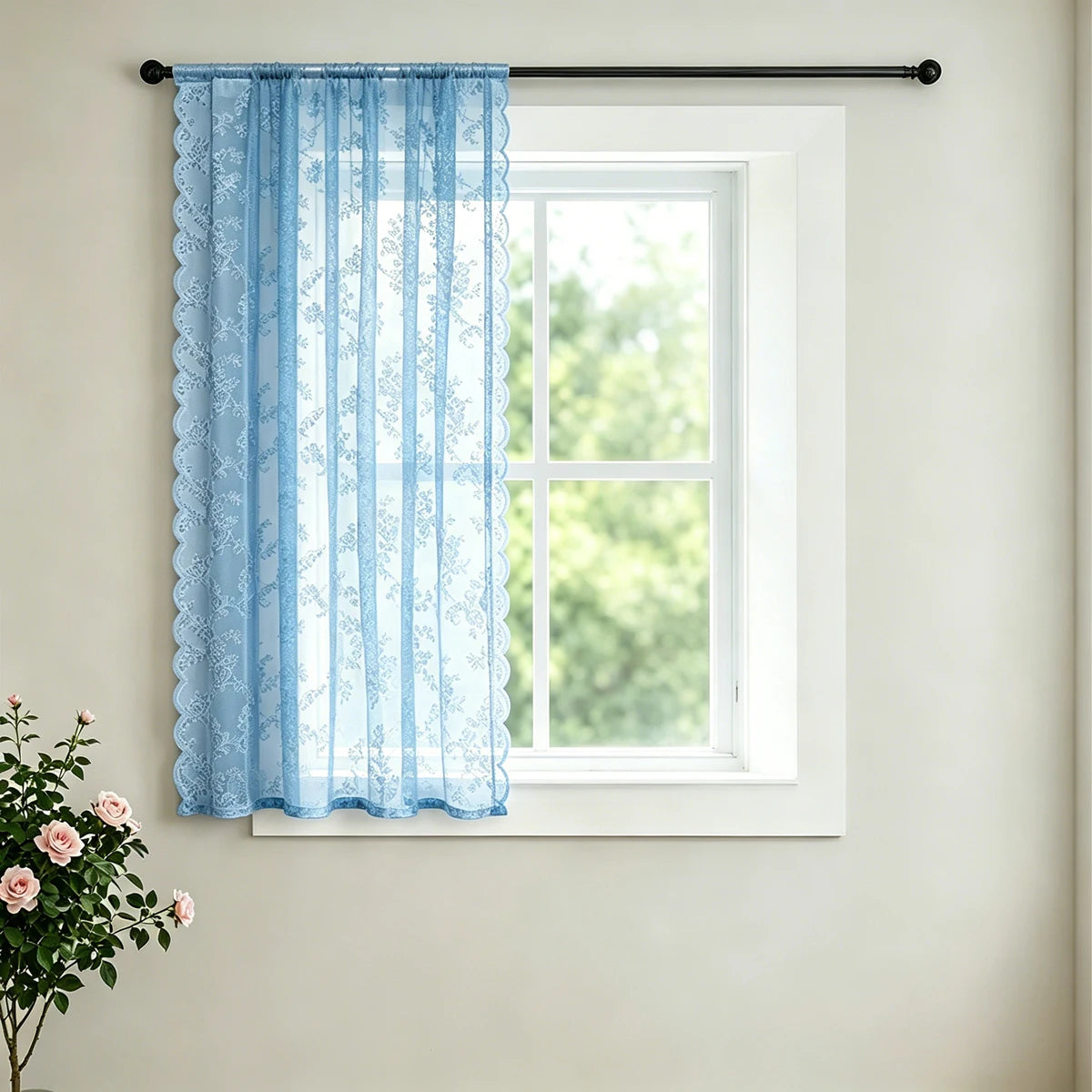 Light blue vintage French-style lace curtain hanging on a white window frame.