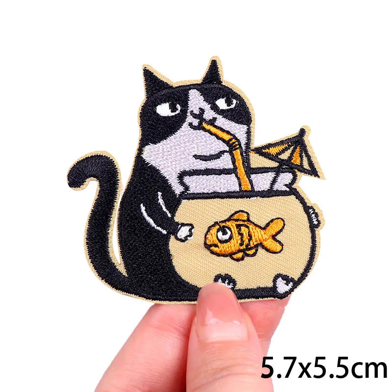 Embroidered patch featuring a cartoon black and white cat holding a fish