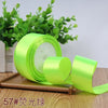 Roll of bright lime green satin ribbon for gift wrapping and DIY crafts